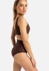 Hnedý vzorovaný bikiny set s braletovou vrchnou časťou, širokými ramienkami a vysoko pásovými spodkami, oboma zdobenými tmavými kvetinovými motívmi.
