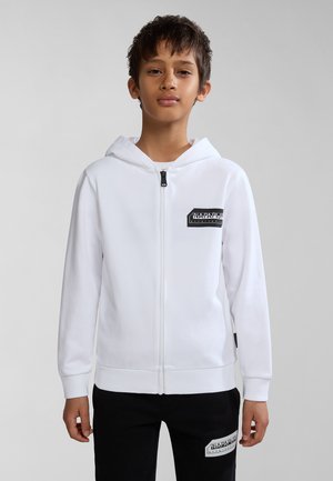 Sudadera blanca con cremallera y bolsillo frontal, con parche de logo negro, que cuenta con capucha y puños acanalados, combinada con pantalones negros que muestran un logo.