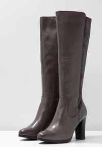 Bottes jusqu'au genou en cuir et daim gris foncé, présentant un bout rond et un talon haut épais avec une surface texturée.