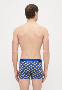 Modré boxerky s opakujúcim sa vzorom žltých gumových kačičiek a kontrastným modrým pásom s textom "HAPPY."