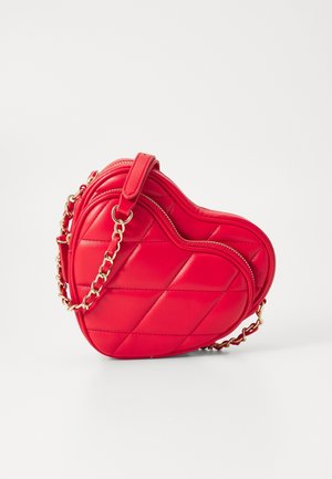 Bolso de mano rojo con forma de corazón acolchado, con cadena dorada y cierre de cremallera, exhibido sobre un fondo blanco.
