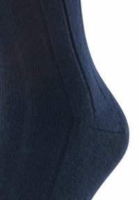 Marineblaue Socke mit strukturiertem Muster, glatter Oberfläche und verstärktem Fersenbereich. Entwickelt für Komfort und Langlebigkeit.
