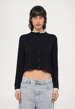 Svart kort cardigan med rund hals, med en ljusgrå krage, hel knäppning framtill och långa ärmar, tillverkad av ett mjukt stickat material.