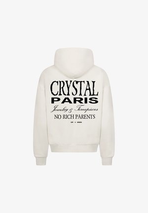 Biała bluza z kapturem z dużym czarnym napisem na plecach, który brzmi "CRYSTAL PARIS Biżuteria i Zegarki BEZ BOGATYCH RODZICÓW."