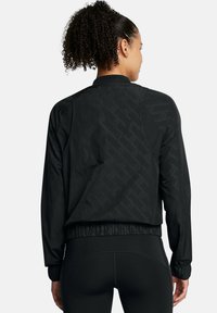 Schwarze Bomberjacke mit dezentem geprägtem Muster, gerippten Bündchen und Saum. Leichter Stoff und lockere Passform. Geeignet für aktive Freizeit.