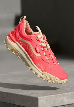 Pink trail running shoe with beige accents, waterproof Gore-Tex material, textured sole, and lacing system. Vibram outsole for traction.