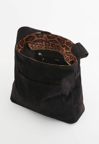 Sort ruskind tote taske med åben top, som har et indre med leopardmønster og en lynlåslomme. Inkluderer en yderlomme til opbevaring.