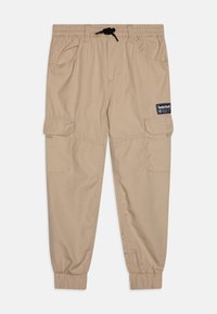 Beige cargobroek met een elastische tailleband en een trekkoord. Voorzien van zijzakken en geribbelde boorden. Timberland-logo patch op de voorkant.