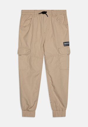 Beige cargobroek met een elastische tailleband en een trekkoord. Voorzien van zijzakken en geribbelde boorden. Timberland-logo patch op de voorkant.
