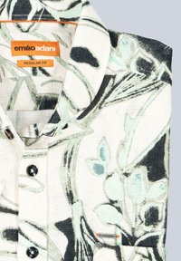 Baumwollhemd in Creme mit grünem und schwarzem Blumenmuster. Mit einem Button-Down-Kragen und kurzen Ärmeln, sowie einem Etikett und einer Brusttaschen-Applikation.