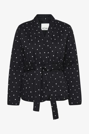 Prošívaná černá bunda s bílým vzorem srdcí, zavinovací design, uzavírání na přední straně na zavazování a dlouhými rukávy. Obsahuje strukturovanou tkaninu a bez límce.
