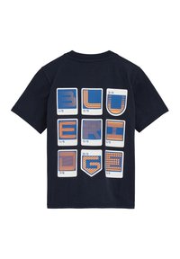 Tamsiai mėlyna medvilninė marškinė su retro stiliaus grafika, kurioje yra devynios kvadratinės formos, kiekviena iš jų rodo skirtingus raštus mėlynos ir oranžinės spalvų.