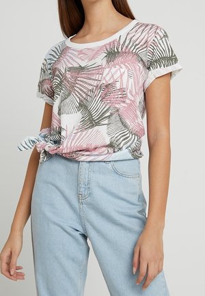 Short-sleeve white t-shirt with pink and green palm leaf print; knotted at the hem, paired with light blue high-waisted jeans.