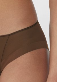 Brązowa bielizna hipsterska wykonana z gładkiego materiału. Posiada szeroki pasek oraz subtelną teksturę siateczkową po bokach. Prosty i nowoczesny design.