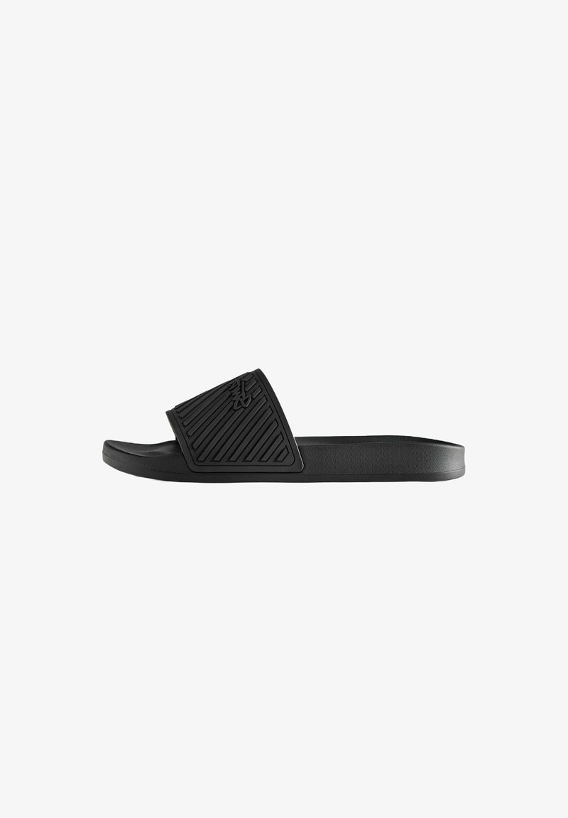 Sandale slide noire avec bride inclinée texturée et logo embossé, équipée d'une semelle profilée et d'un design à bout ouvert.