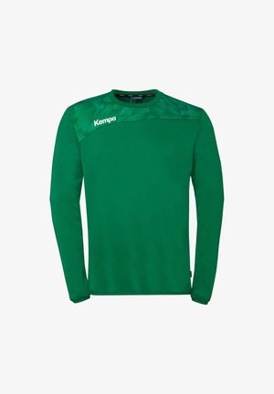 Chemise de sport verte à manches longues avec motif géométrique sur le haut de la poitrine et logo "Kempa" sur l'épaule gauche.