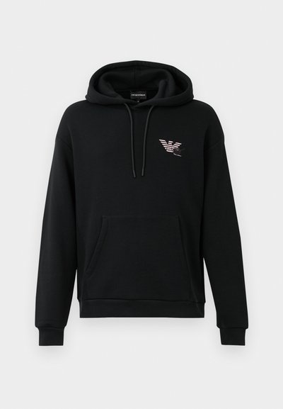 Črna kapuca s žepom spredaj in majhnim stiliziranim orlom na levi prsni strani, z vrvicami pri kapuci.