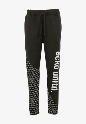 Zwarte joggingbroek met een verstelbare tailleband, een wit logo en tekst aan de voorkant, en een gestreepte zijpaneel met herhalende ontwerpen.