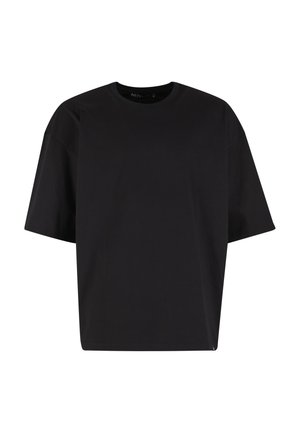 T-shirt noir à manches courtes oversize avec col rond et coupe décontractée sur fond blanc uni.