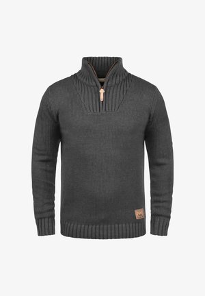 Suéter de punto gris oscuro con un cuello alto, cremallera de un cuarto, puños y dobladillo acanalados, y un patrón texturizado. Incluye un parche de logo de cuero.