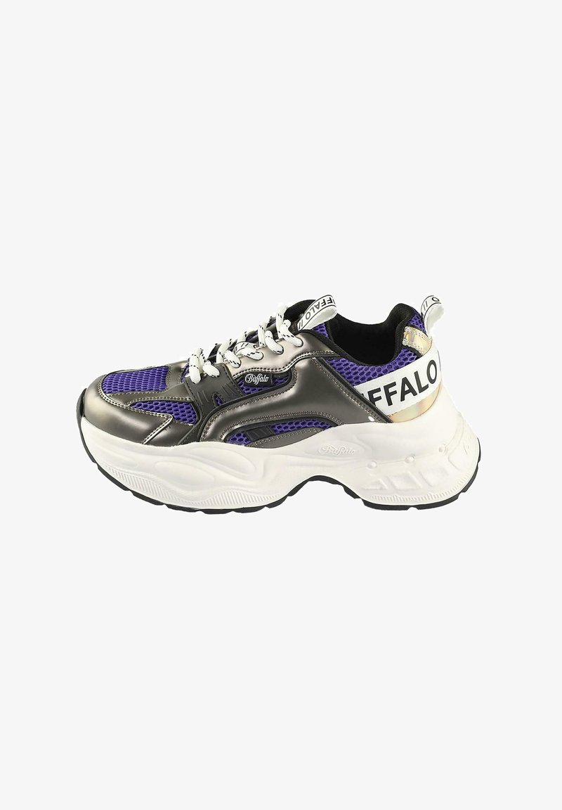 Masívne tenisky s metalicky strieborným zvrškom a fialovými sieťovinovými akcentami, bielymi šnúrkami, výrazným brandingom na päte a textúrovanou bielou podrážkou.