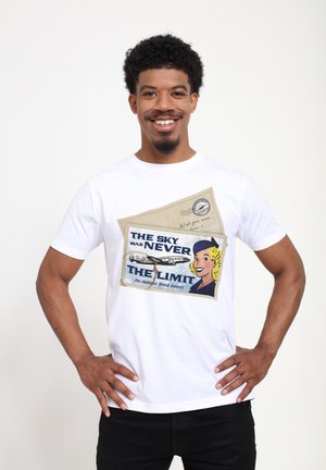 Witte katoen t-shirt met een grafische print van een retro ansichtkaart met een vrouw, een vliegtuig en de tekst: "DE LUCHT WAS NOOIT DE BEPERKING."