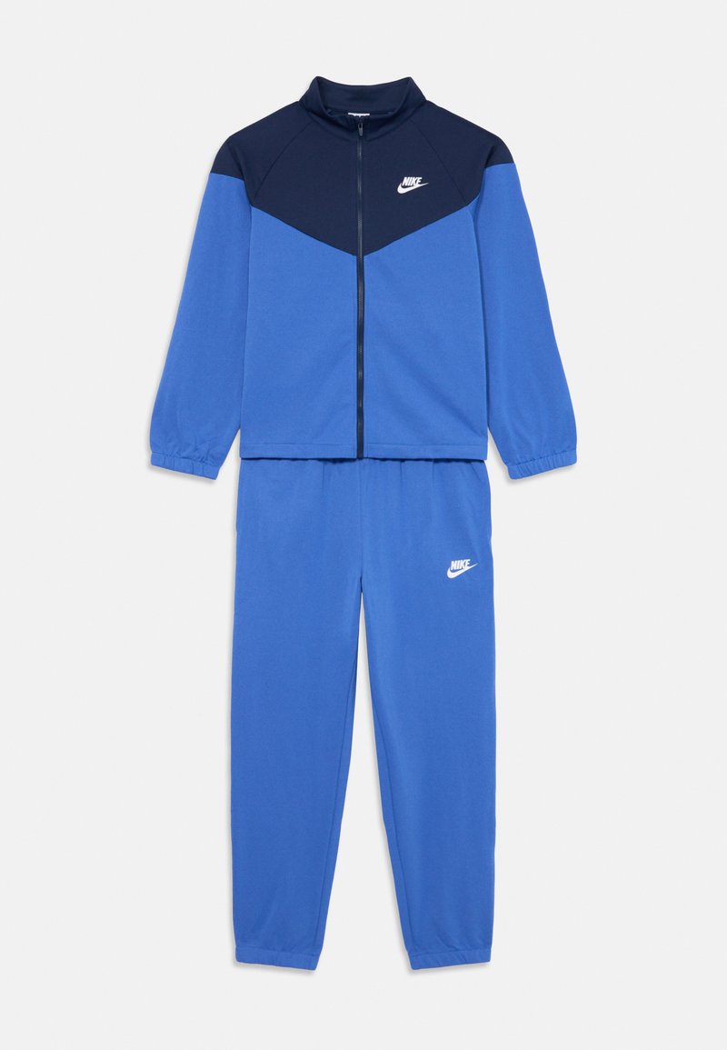Modrý a námořnický Nike teplákový komplet s zipovou bundou, která má bílou značku, elastické manžety a pas, a odpovídající modré kalhoty s bílou značkou.