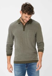 Longsleeve-Polohemd in Olivgrün, mit strukturiertem Stoff, geripptem Kragen und Manschetten sowie einer Brusttasche. Mit geradem Saum abgeschlossen.