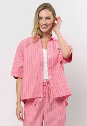 Rózsaszín csíkos, rövid ujjú ing, hímzéssel díszítve, könnyű anyagból készült, hozzá illő nadrággal párosítva.