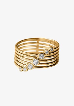 Anillo multifibra de oro con siete diamantes blancos redondos de diferentes tamaños colocados en diagonal a lo largo de las bandas.