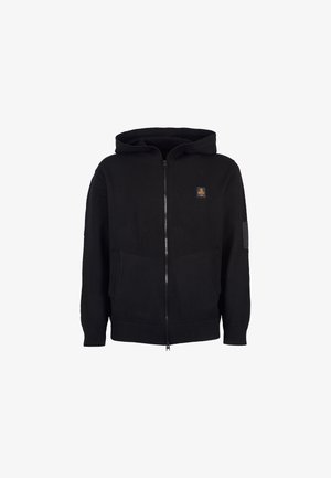 Felpa con zip nera realizzata in morbido tessuto, caratterizzata da un cappuccio, due tasche frontali, polsini e orlo a costine, e una piccola toppa con logo sul petto.