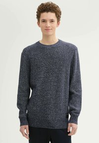 Miodowy granatowy sweter dzianinowy z długimi rękawami, okrągłym dekoltem i fakturowanym materiałem. Posiada metkę na dolnej lewej stronie.