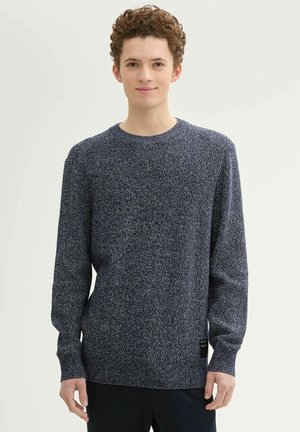 Gebreid marineblauw trui met lange mouwen, ronde hals en een textuurstof. Bevat een label aan de onderkant aan de linkerkant.
