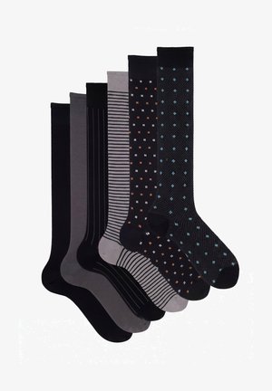 Sechs Paar knielange Socken in Schwarz und Grau mit unterschiedlichen Mustern, darunter Streifen und kleine farbige Punkte.