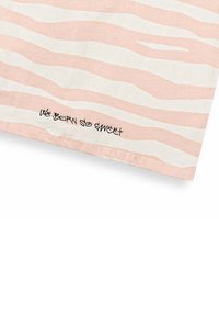 Tela de algodón con franjas onduladas alternas en rosa y blanco; presenta texto escrito a mano en negro que dice "quemamos tan dulce" a lo largo del dobladillo.
