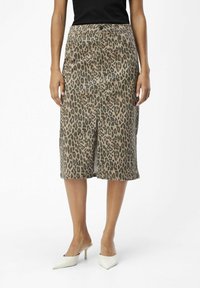 Jupe midi à imprimé léopard en tissu doux, avec une fente devant, un détail bouton à la taille et une texture lisse aux tons beige et marron.