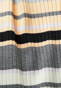 Ribba neulottu kangas, jossa on vuorotellen vaakasuoria raitoja keltaisena, mustana, harmaana ja valkoisena, ja joissa on vaihtelevaa rakennetta ja leveyksiä.