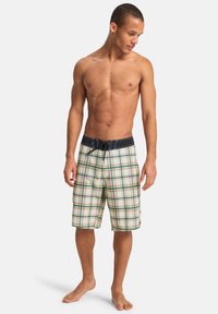 Ανδρικά καρό μαγιό σε μπεζ, πράσινο και μοβ, με κορδόνι στη μέση και επένδυση από δίχτυ. Στυλ 90s με μήκος μέχρι το γόνατο.