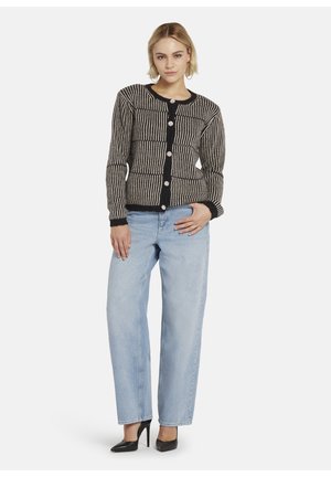 Zwart en beige gestreepte cardigan met een ronde halslijn, knoopsluiting en ribgebreide manchetten, gecombineerd met lichtblauwe wijde jeans en zwarte hakken.