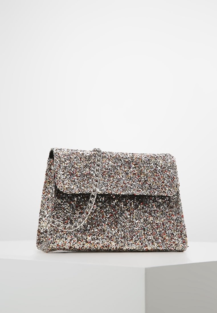 Błyszcząca srebrna torebka wykonana z błyszczącego materiału o teksturowanej powierzchni, z klapką na zapięcie i srebrnym łańcuszkiem.