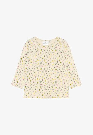 Top crema con mangas de tres cuartos, que presenta un patrón floral en tonos rosa y amarillo sobre una textura acanalada. Cuello redondo y corte relajado.