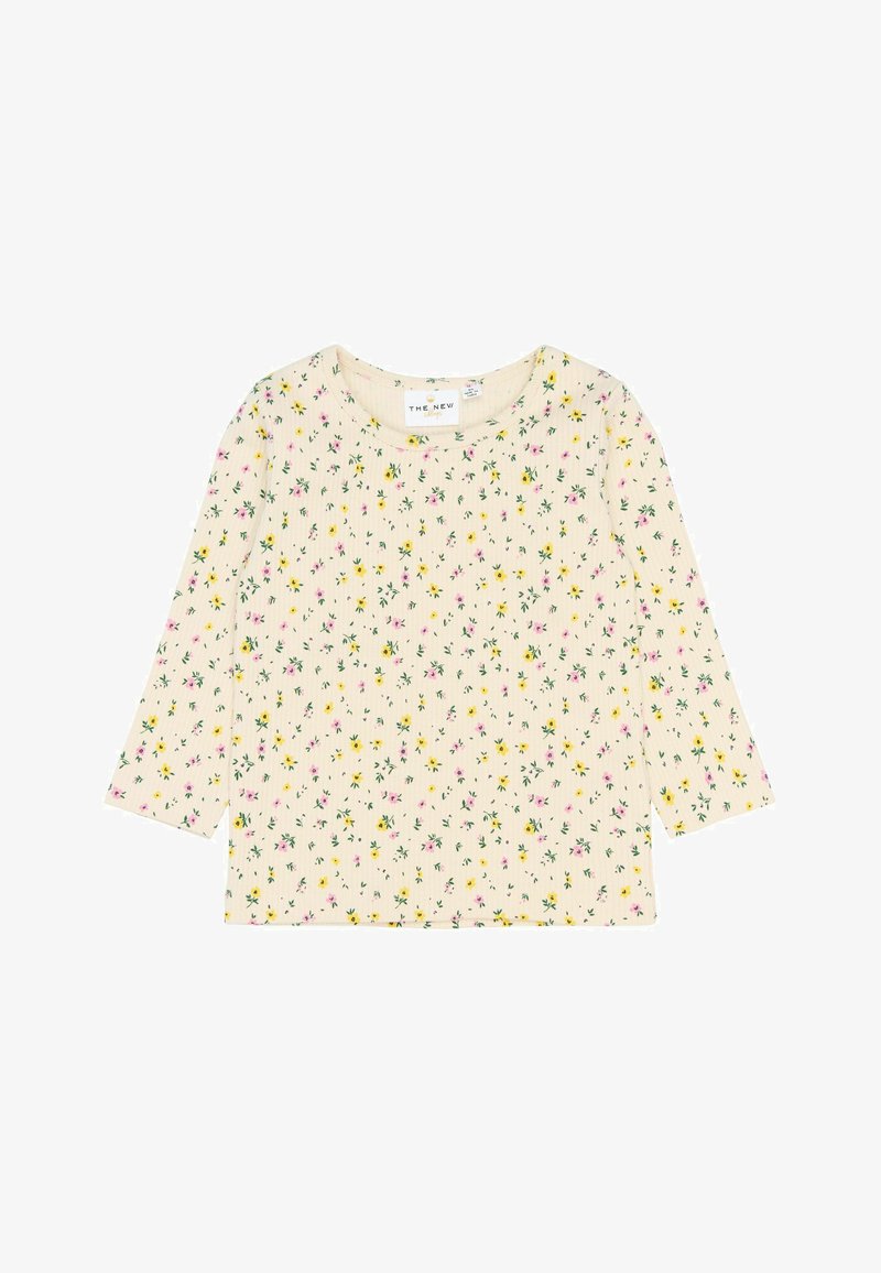 Kremines tops ar trīs ceturtdaļu piedurknēm, ar ziedu rakstu rozā un dzeltenā krāsā uz ribota auduma. Apaļš kakls un brīvs griezums.