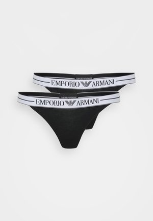 String noir en tissu doux, avec une ceinture élastique blanche portant l'inscription "EMPORIO ARMANI". Design simple avec un minimum de coutures.