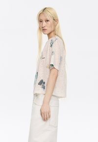 Korte mouwen blouse in lichtroze, met bloemmotieven in blauw, groen en zwart, gemaakt van een textuurstof en met een boxy silhouet.