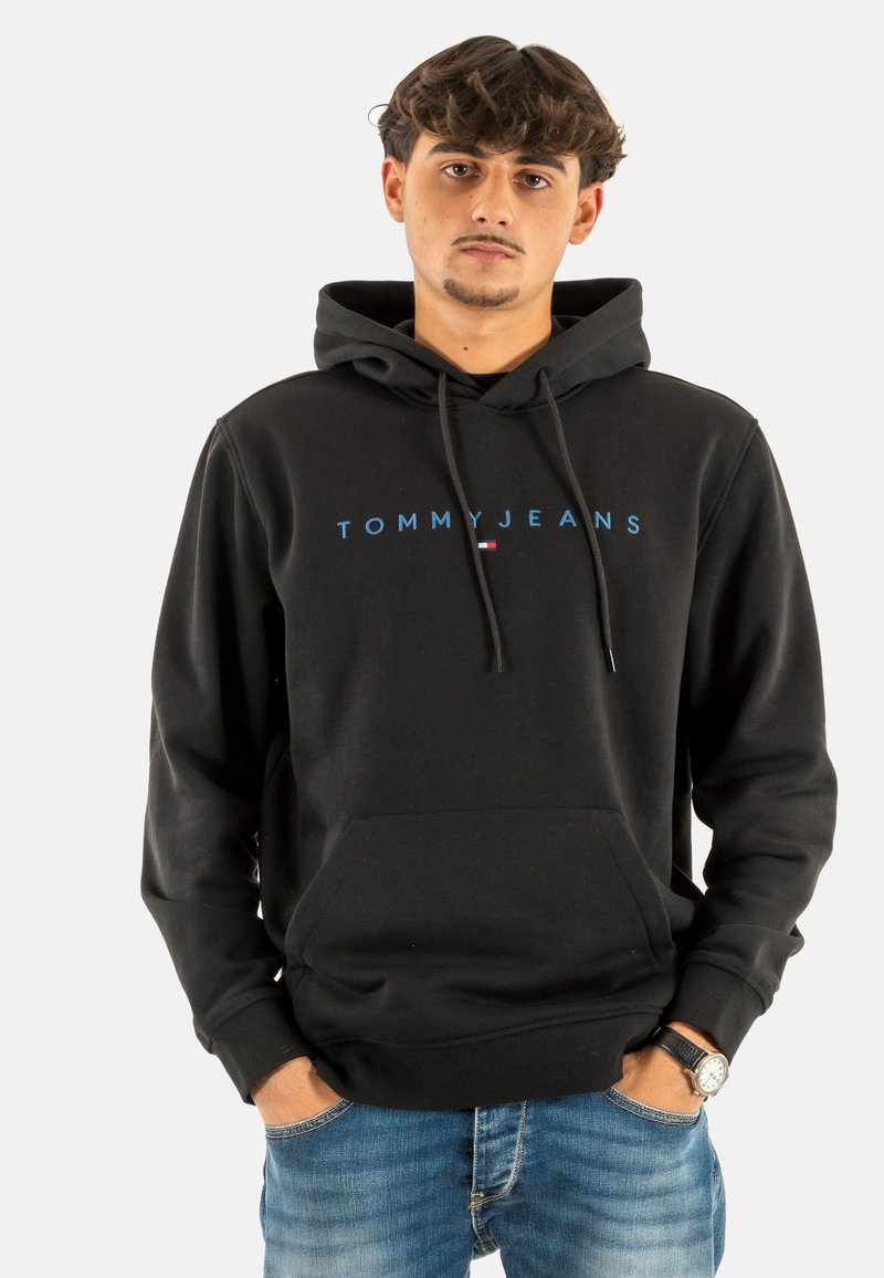 Felpa nera con cappuccio in cotone, dotata di tasca frontale e logo "TOMMYJEANS" blu sul petto. Taglio casual e tessuto testurizzato.