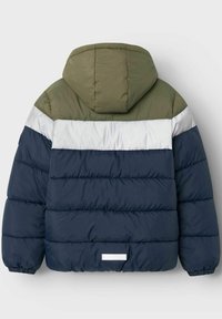 Veste à capuche rembourrée avec des blocs de couleur vert olive, blanc et bleu marine. Texture douce avec des poignets élastiques et une petite étiquette blanche à l'arrière.