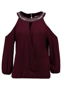 Bordeaux bluse med kold skulder design, pyntet halsudskæring, lange ærmer og indpakket frontstil. Blødt stof med en tekstureret overflade.