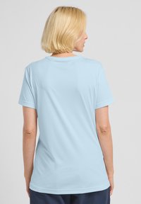 T-shirt azzurro chiaro con maniche corte e scollatura rotonda, realizzato in tessuto liscio. La parte posteriore presenta un design semplice senza loghi visibili.