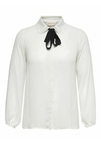Blusa blanca de manga larga con un collar estructurado y una lazada negra en el cuello, con tela suave y un ajuste entallado.