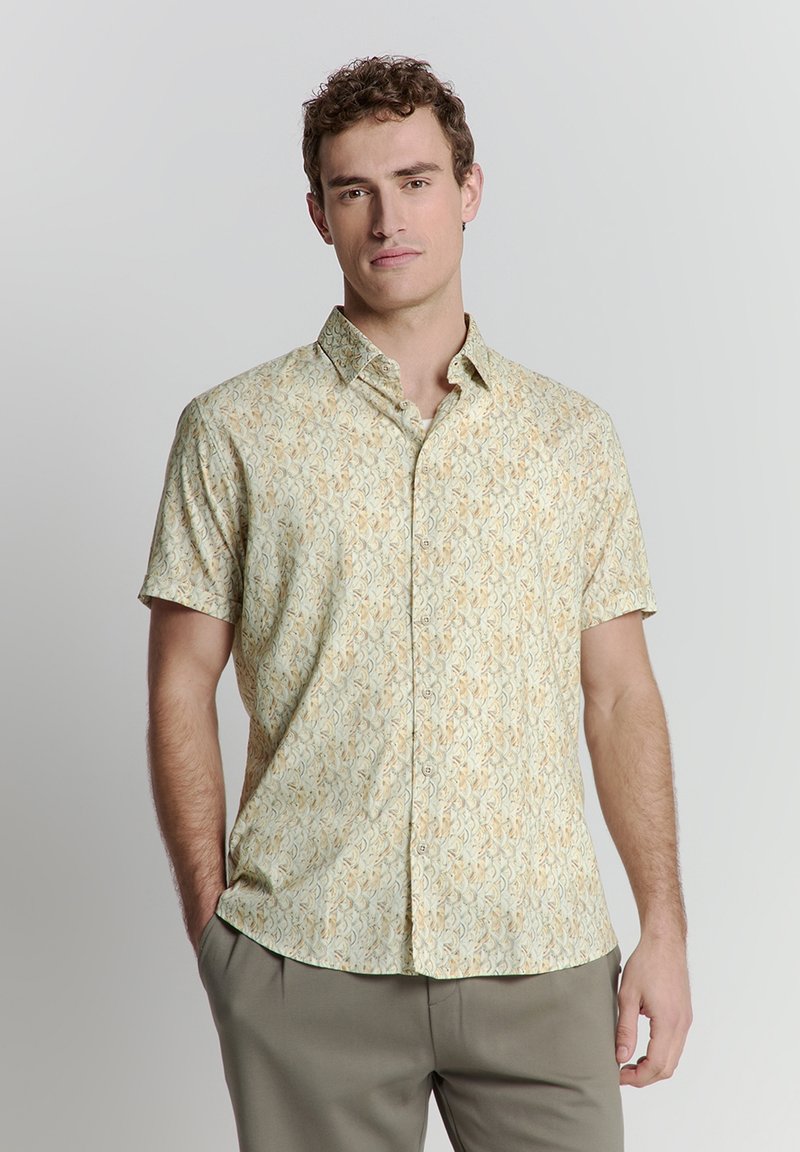Kurzärmliges Hemd mit Knopfleiste in Hellgrün mit einem komplexen, abstrakten Muster in Creme und Braun. Aus leichtem Stoff für hohen Tragekomfort.